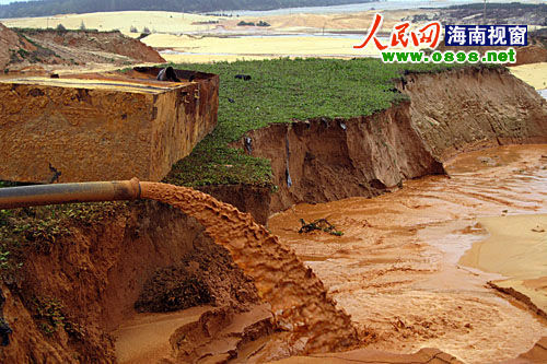 “粗大的水管正在排放采鈦礦產(chǎn)生的尾砂和污水。”在海南文昌市昌灑鎮(zhèn)白土村牧場(chǎng)坡附近，大型采礦機(jī)正在熱火朝天的運(yùn)轉(zhuǎn)。為了2000多元的工資，兩位打工者不顧一切，被“圍”在數(shù)十米深的礦坑里工作。圖為文昌昌灑鎮(zhèn)白土村牧場(chǎng)坡附近的采鈦礦現(xiàn)場(chǎng)