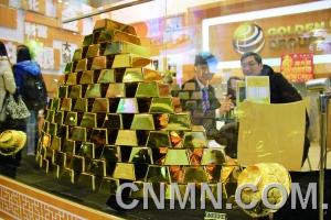 參展的金行在現場展臺用金磚壘出小“金字塔”，吸引了眾多投資者的目光。