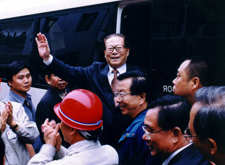 “同志們好！”“大家好！”邁出車門的江澤民向激動沸騰的西南鋁職工微笑地點頭，爽朗地問好，親切地揮手致意。（李影攝）