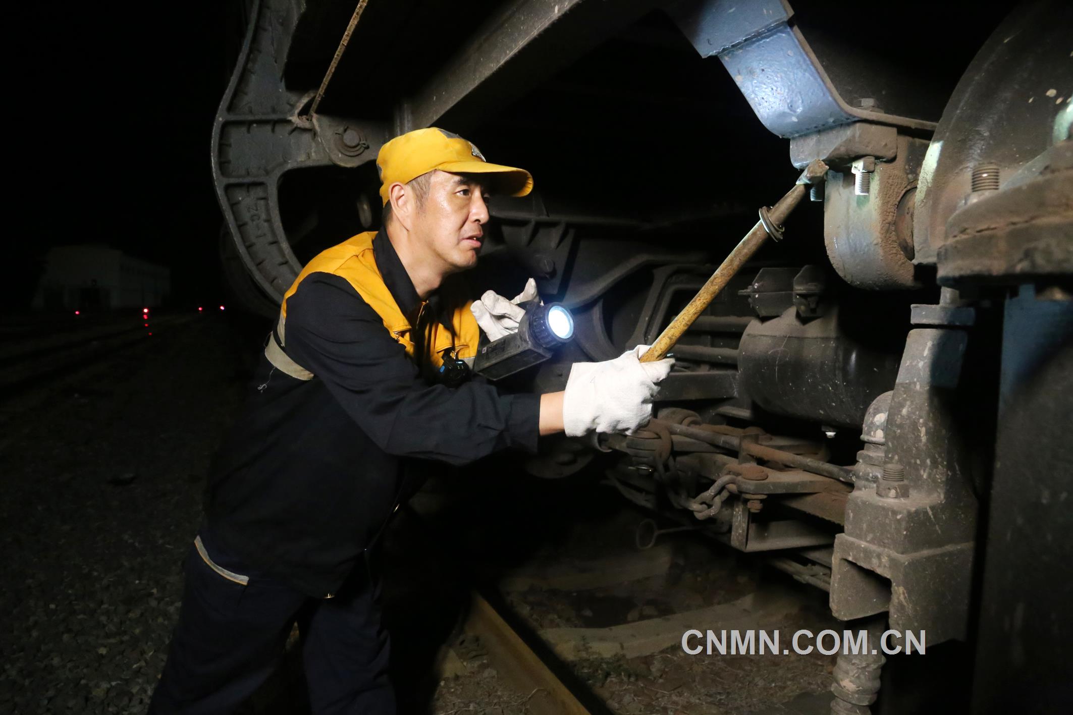 焦建智正在對待發(fā)礦石專列進行發(fā)車前的技術檢查。